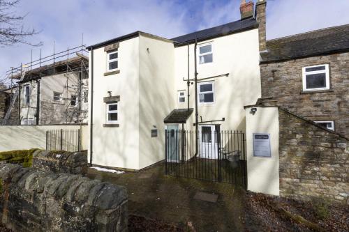 a white building with a gate and a stone wall at H C Property - Chapel Race Countryside Retreat in Saint Johns Chapel