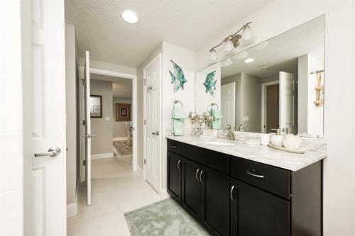 a bathroom with two sinks and a large mirror at Unit 102 Aruba - 3 Bedroom Ocean Front in Daytona Beach