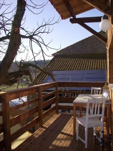 une terrasse en bois avec une table et une chaise. dans l'établissement Un havre de paix, à Aigues-Vives