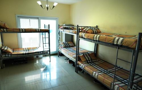 a room with three bunk beds and a window at Decent Holiday Homes & Hostels near Burjuman Metro Station in Dubai