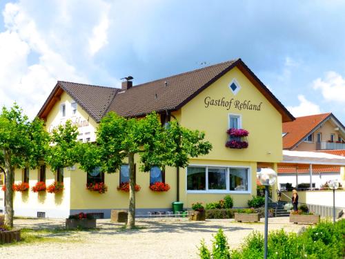 a yellow building with flowers on the windows at Gasthof Rebland in Eichstetten