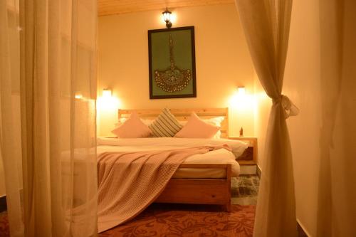 ein Schlafzimmer mit einem Bett mit weißen Kissen in der Unterkunft Musafir cottage in Pālampur