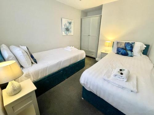 two beds in a room with two tables and lamps at The Bungalow 1A Wenlock in York
