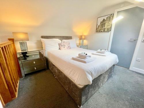 a bedroom with a large bed with two towels on it at The Bungalow 1A Wenlock in York