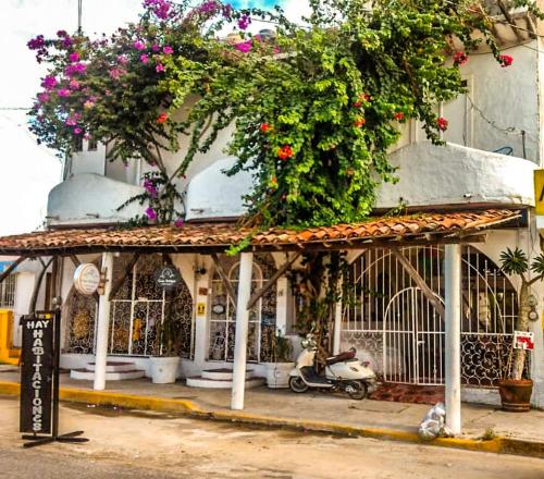 a scooter parked in front of a building with flowers at Posada Casa Antigua in Tecolutla