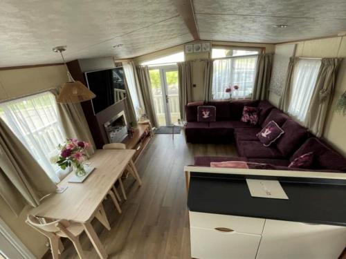 a living room with a couch and a table at Sea Breeze a beautiful 3 bedroom coastal caravan in Milford on Sea