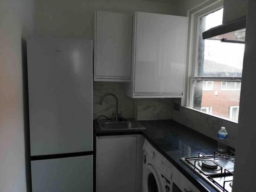 a small kitchen with a sink and a stove at Cosy Entire Flat in Kings Cross in London