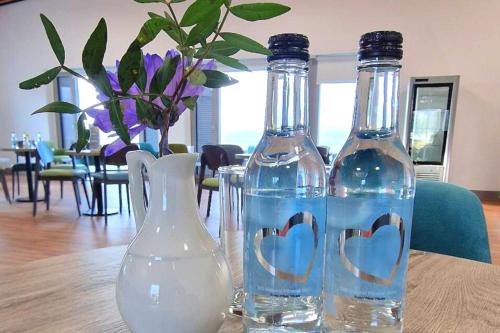 two bottles of water on a table with a vase at Caban, Pendine Sands in Pendine