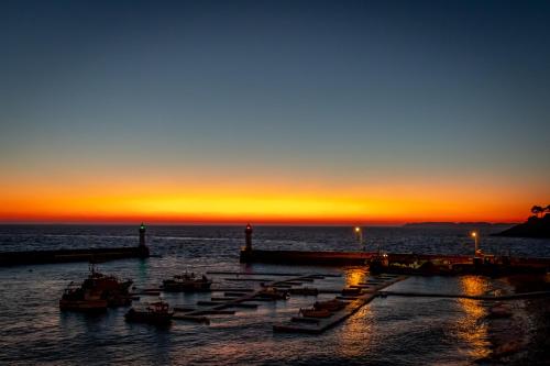a group of boats in the water at sunset at Hotel Atlantique in Le Palais