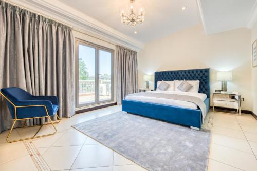 ein Schlafzimmer mit einem blauen Bett und einem blauen Stuhl in der Unterkunft Stunning Villa with Private Pool & Beach Access in Dubai