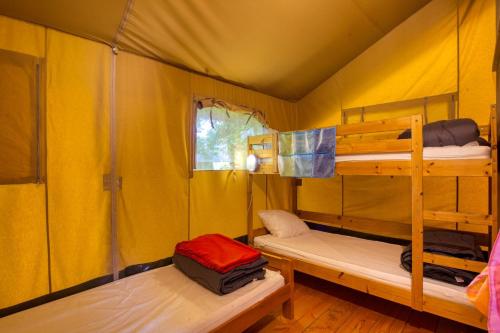 クー・エ・ビガロックにあるCamping le Clouのテント内の二段ベッド2台が備わる客室です。