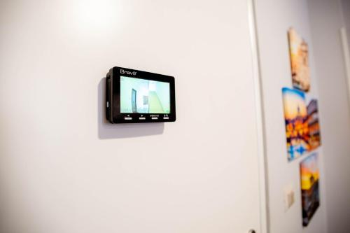 a television on a white door with a wall at DOMUS PETRI- CASA A S. PIETRO in Rome