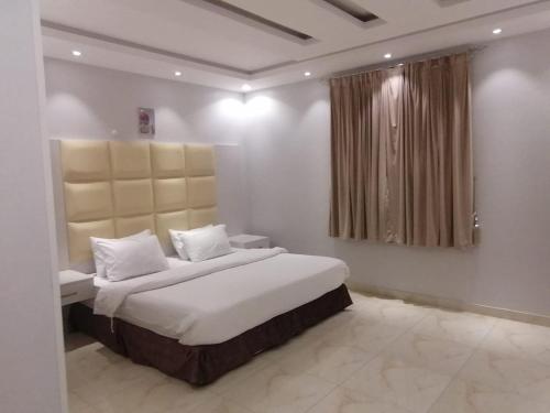 a bedroom with a large bed and a window at العرين بارك للشقق المخدومة in Abha