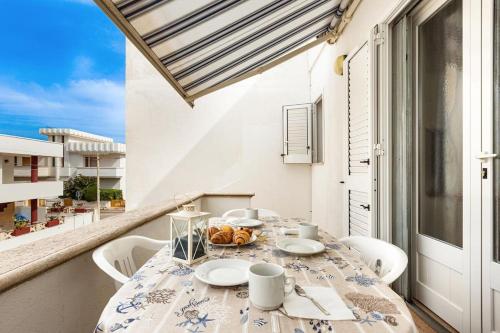 een tafel en stoelen op een balkon met uitzicht op de oceaan bij Salentoandmore - Casa Stella in Torre Pali 