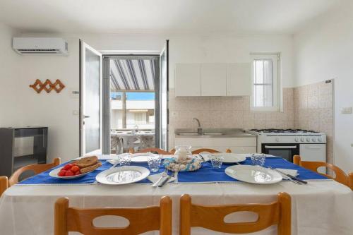 een keuken met een tafel met een blauwe tafeldoek bij Salentoandmore - Casa Stella in Torre Pali 