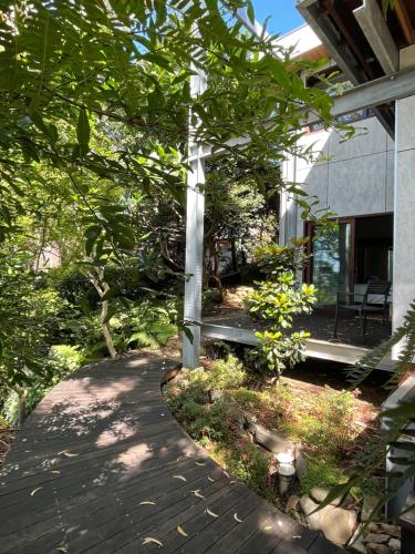 a walkway in front of a house with trees at Tranquil Garden Studio in Wollongong