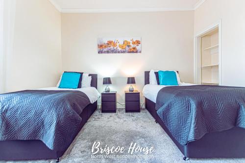 two beds sitting next to each other in a bedroom at Briscoe Serviced Accommodation in Manchester