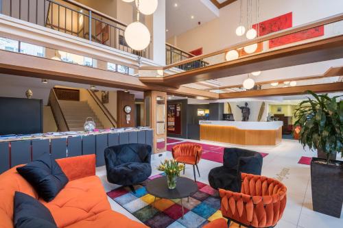 a lobby with a couch and chairs and a bar at Best Western Hotel Augusta in Augsburg