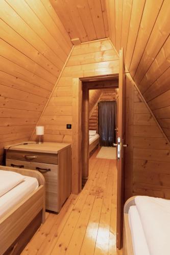 a room with two beds in a wooden cabin at Alpska kuća Lucy in Jasenak