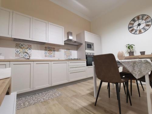 a kitchen with white cabinets and a table and chairs at Casa Marinella in Crotone