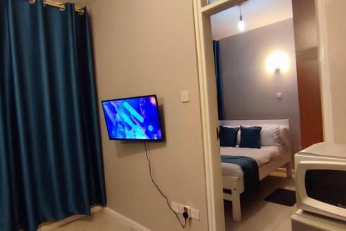 Pokój z telewizorem wiszącym na ścianie w obiekcie One bedroom fully furnished apartment w mieście Kiambu