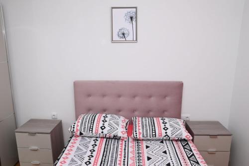 a bedroom with a bed with a pink headboard at Z&R SUNLIGHT in Trebinje
