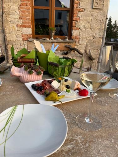 a table with a plate of food and a glass of wine at Ferienhaus Weißburgunder am Weinberg in Naumburg