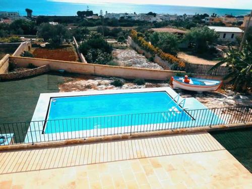 a swimming pool on top of a house with a boat at Salentoandmore - Villa Adrian in Torre Vado