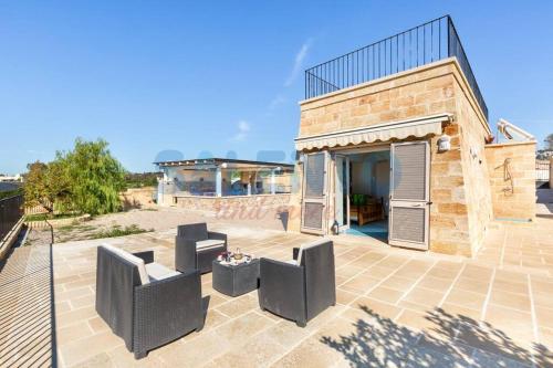 a patio with two chairs and a building at Salentoandmore - Villa Adrian in Torre Vado