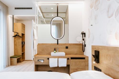 a bathroom with a sink and a mirror at BEE GREEN Linz Self-Check-in-Hotel in Linz