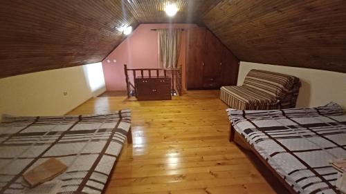 a attic room with two beds and a couch at Holiday Home Nikolić in Njeguši