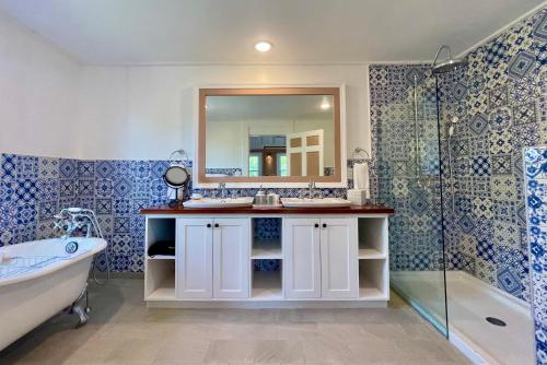 uma casa de banho com 2 lavatórios, uma banheira e um espelho. em Weatherills Hotel em Cedar Grove
