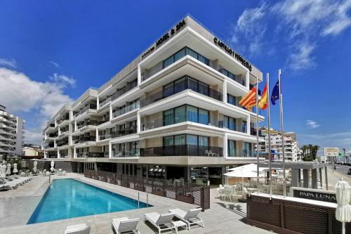 ein Hotel mit einem Pool vor einem Gebäude in der Unterkunft Hotel & Spa Castillo de Peñíscola 4* Sup in Peñíscola