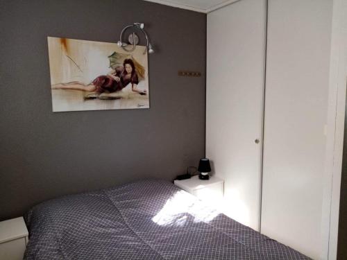 a bedroom with a bed and a painting on the wall at Zenatitude in Marseillan