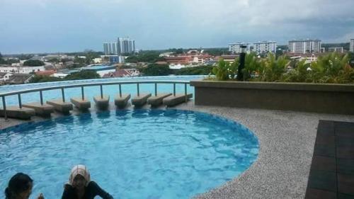 a couple of people laying in a swimming pool at KB Studio @D'Perdana Apartment in Kota Bharu