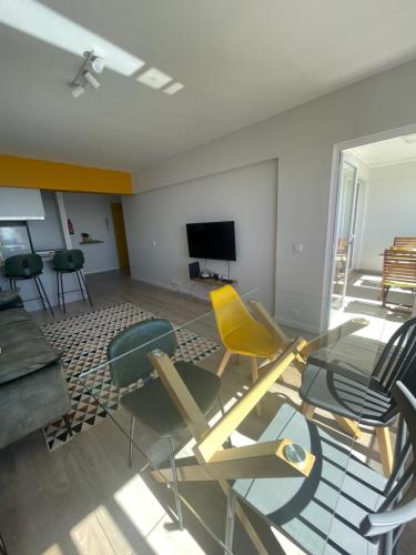 ein Wohnzimmer mit Stühlen, einem Tisch und einem TV in der Unterkunft top floor avenida arriaga 802 in Funchal
