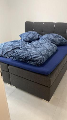 ein Bett mit blauer Bettwäsche und Kissen darauf in der Unterkunft Charmante Ferienwohnung-Neubau- in Taunusstein