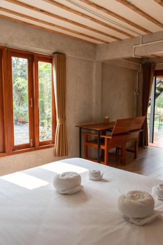 a bedroom with a bed with towels on top of it at Banmai87 Guest House บ้านไม้87 เกสต์เฮ้าส์ in Phra Nakhon Si Ayutthaya