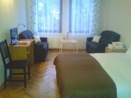 a hotel room with a bed and a desk and chairs at Hotel Hinovi Hvoyna in Hvoyna
