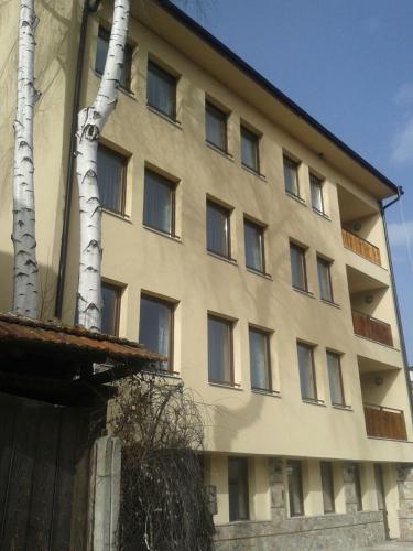 a building with a tree in front of it at Hotel Hinovi Hvoyna in Hvoyna