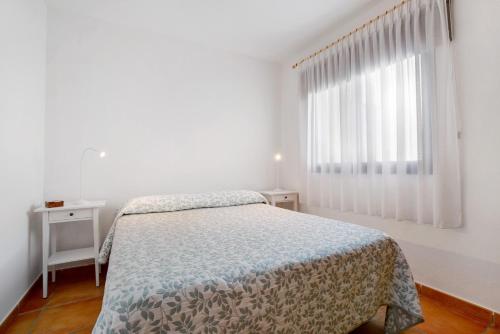 a white bedroom with a bed and a window at Casa Las Vistas in Gran Tarajal