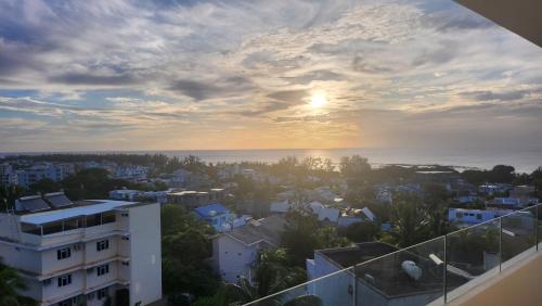 a view of the sunset from the balcony of a building at SEAVIEW LUXURY APPARTMENT in Flic-en-Flac
