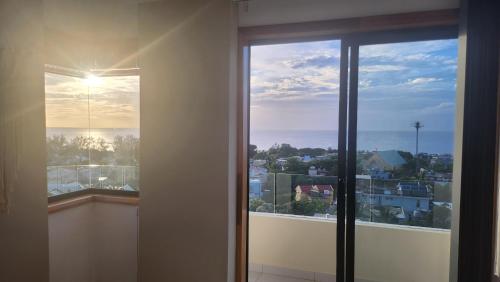 a room with a window with a view of a city at SEAVIEW LUXURY APPARTMENT in Flic-en-Flac