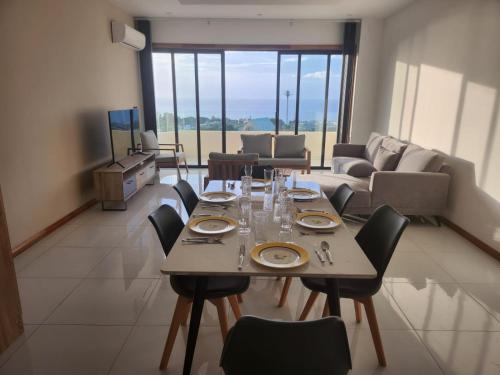 a dining room with a table with chairs and a couch at SEAVIEW LUXURY APPARTMENT in Flic-en-Flac