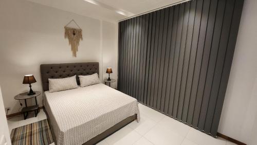 a bedroom with a bed and a large window at SEAVIEW LUXURY APPARTMENT in Flic-en-Flac