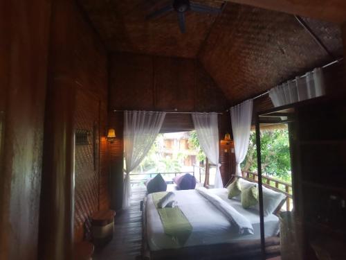 a bedroom with a bed in a room with a window at Gading Tree House in Nusa Penida