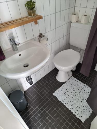 a bathroom with a white sink and a toilet at Juna in Laboe