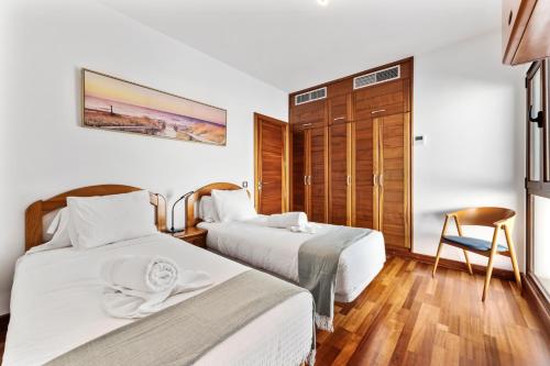 una camera d'albergo con due letti e una sedia di Home2Book Luxury Villa Playa Honda, Private Pool a Playa Honda
