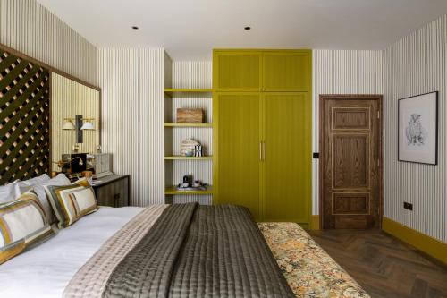 a bedroom with a large bed and a yellow door at The Tempus at Charlton Hall Estate in Alnwick