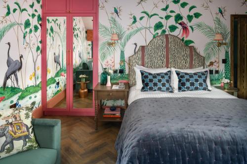 a bedroom with a bed and a mural of birds at The Tempus at Charlton Hall Estate in Alnwick